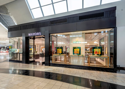 Exterior view of a MAYORS jewelry store with large glass windows and displays inside a shopping mall.