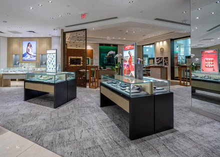 Modern jewelry store interior with glass display cases, bright lighting, and luxury watches on display.