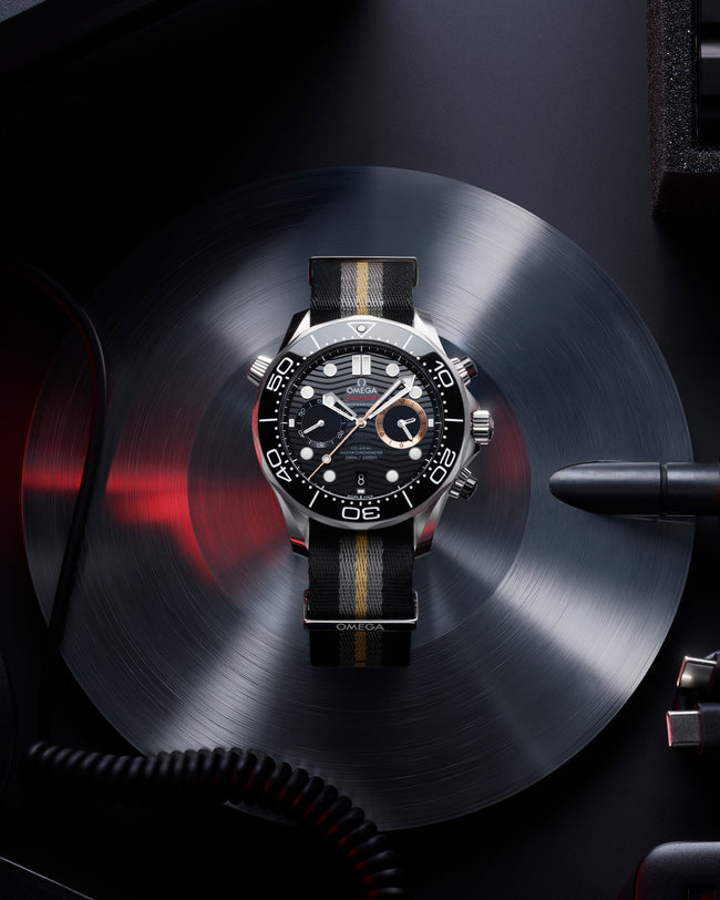 Luxury watch with black dial and leather strap on a dark background