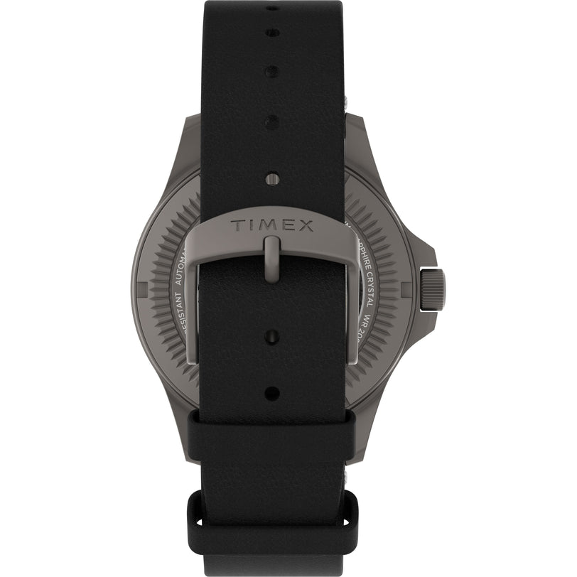 A close-up of the Timex Expedition Titanium Automatic watch shows its black leather strap with a silver buckle, metallic gray case, visible crown, and a scratch-resistant sapphire crystal for added durability.