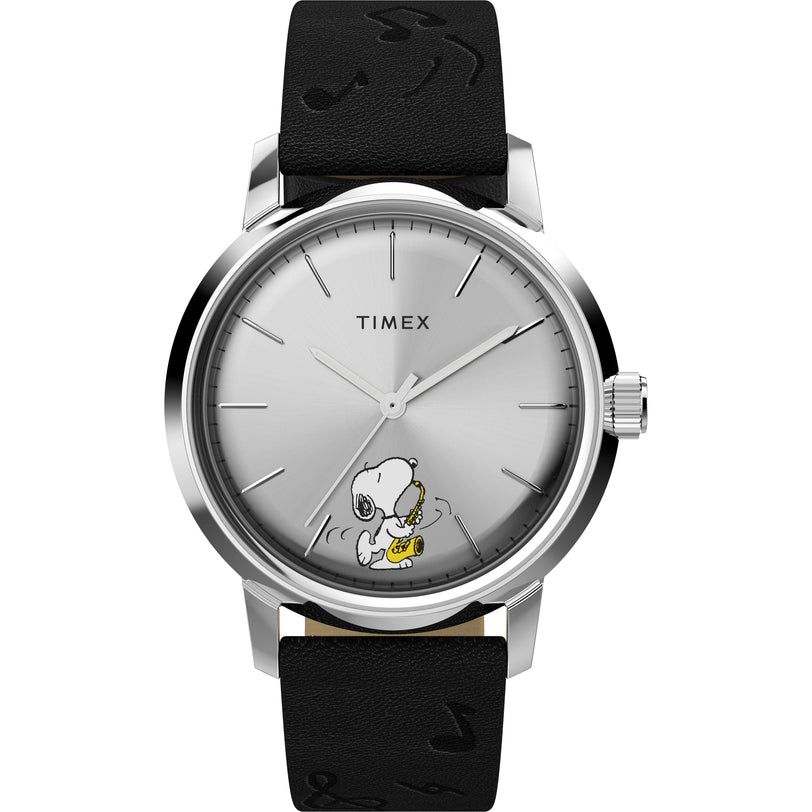 The Timex x Peanuts Marlin® Automatic Saxophonist features Snoopy playing sax on a silver dial, minimalist hour markers, a black leather strap with music notes, and the TIMEX logo, inspired by the classic Marlin Automatic design.