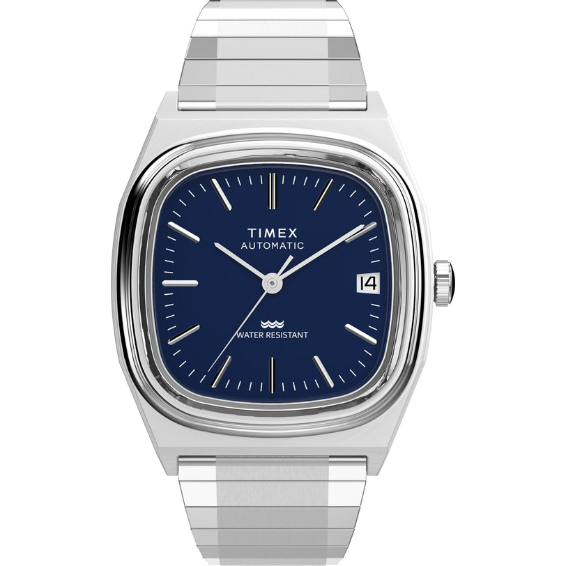 A Timex Automatic 1983 E Line wristwatch featuring a stainless-steel expansion band, square blue dial with silver hour markers, and a date window at 3 o’clock. The dial displays TIMEX AUTOMATIC and WATER RESISTANT.
