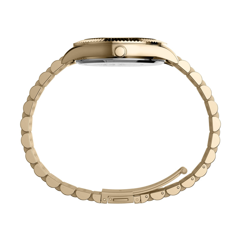 Side view of the Timex x Jacquie Aiche watch by Timex, featuring a gold link bracelet, round case, right-side crown, and lustrous mother-of-pearl dial against a white background.