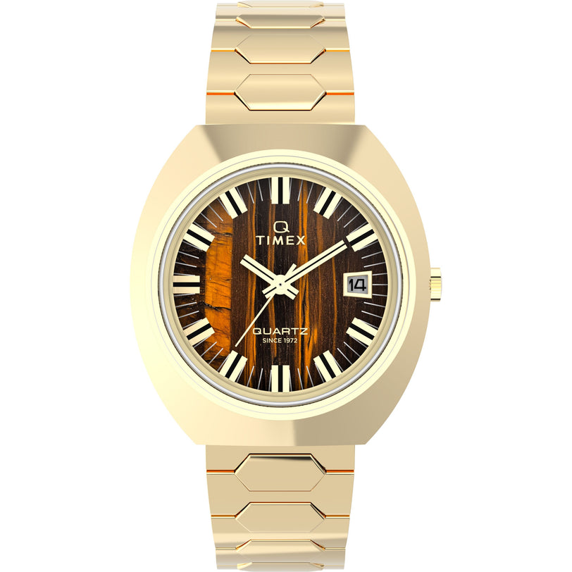 The Timex Q 1972 Time Machine Reissue is a gold quartz watch featuring a hexagonal link bracelet, wood-textured dial, white Roman numerals, date display at 3 o’clock, and a stylish stainless steel tonneau case.