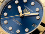 Close-up of a TAG Heuer Aquaracer Professional 200 Solargraph watch face in blue with gold accents and diamond hour markers.