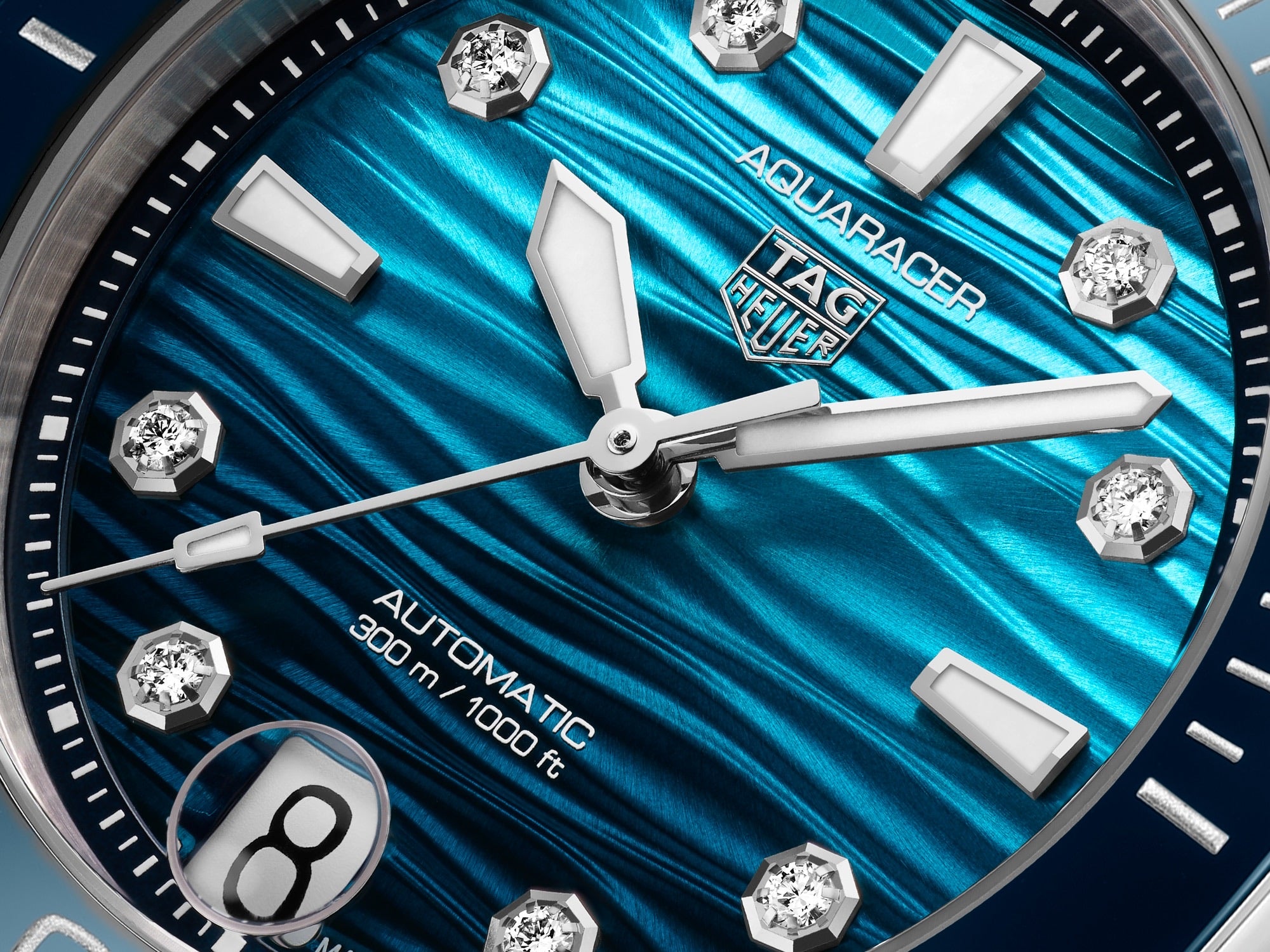 Close-up of a blue TAG Heuer Aquaracer Professional 300 Date watch face featuring diamond hour markers and a date display at 6 o’clock.