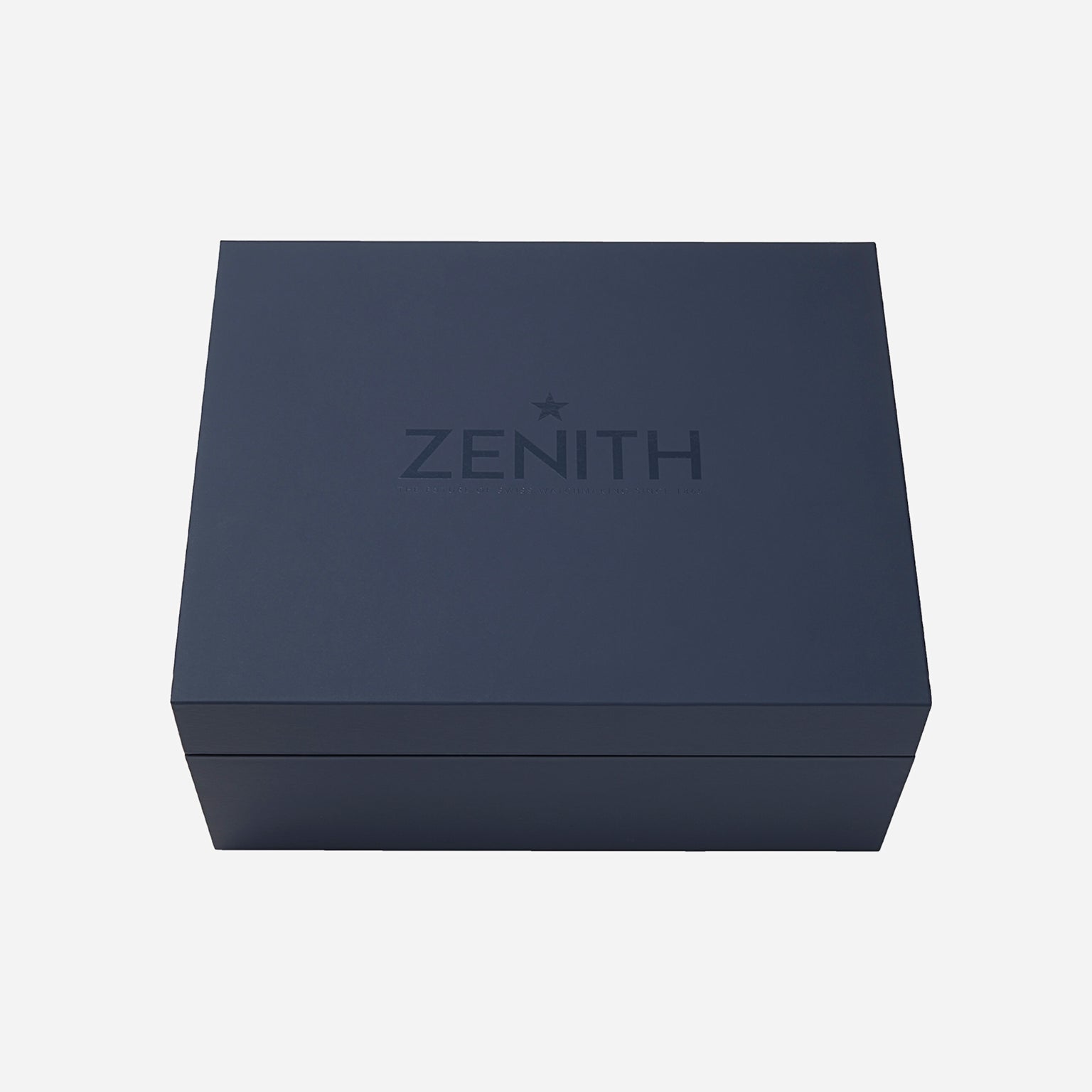 A closed, dark blue rectangular box with Zenith and a star embossed on the lid, reflecting classic style, holds the Zenith Chronomaster Original Limited Edition For Hodinkee, set against a plain white background.