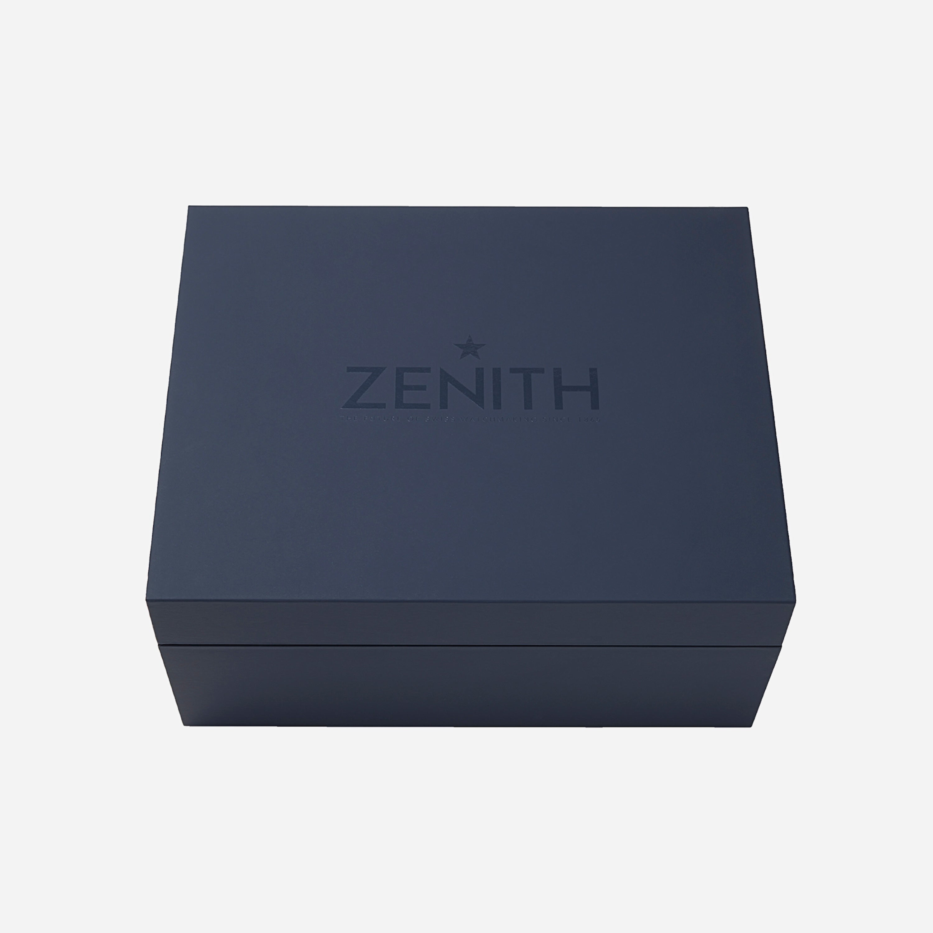 A closed, dark blue rectangular box with Zenith and a star embossed on the lid, reflecting classic style, holds the Zenith Chronomaster Original Limited Edition For Hodinkee, set against a plain white background.