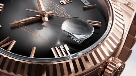 Close-up of a luxury rose gold Rolex watch face, showing the date and Roman numeral markers.