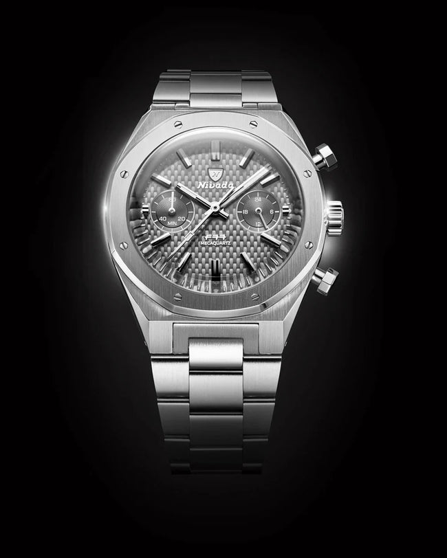 Grey stainless steel chronograph watch with textured dial, subdials, and matching bracelet on black background.