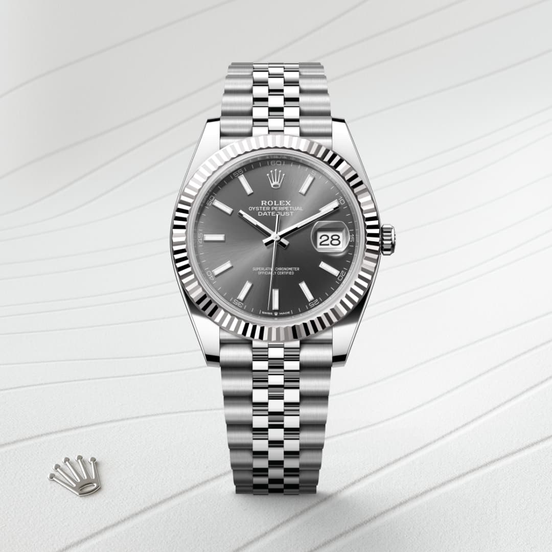 A silver Rolex Datejust watch with a grey dial and jubilee bracelet on a light patterned surface.