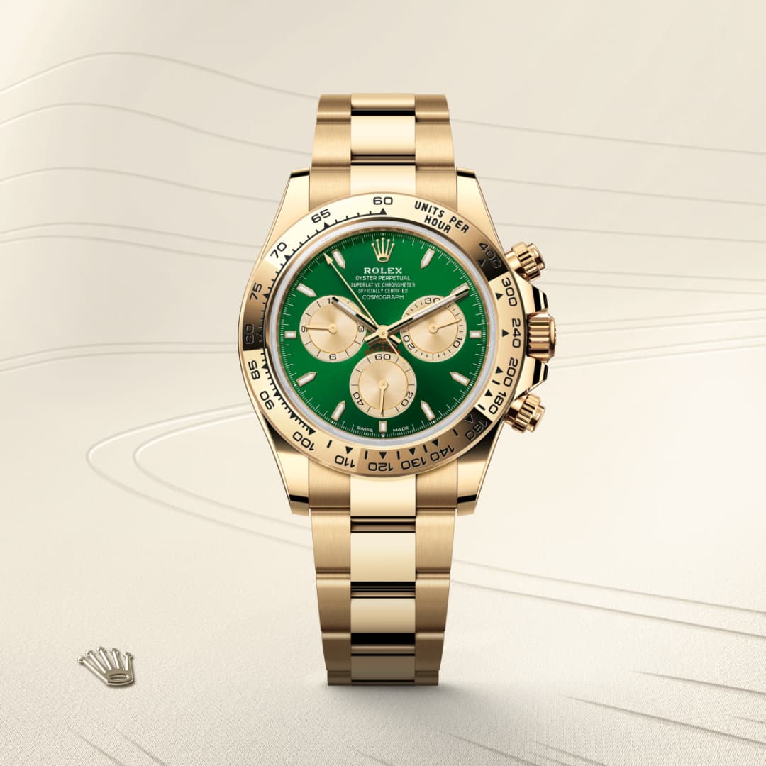 Gold Rolex watch with a green dial and gold subdials, displayed on a light, textured background.