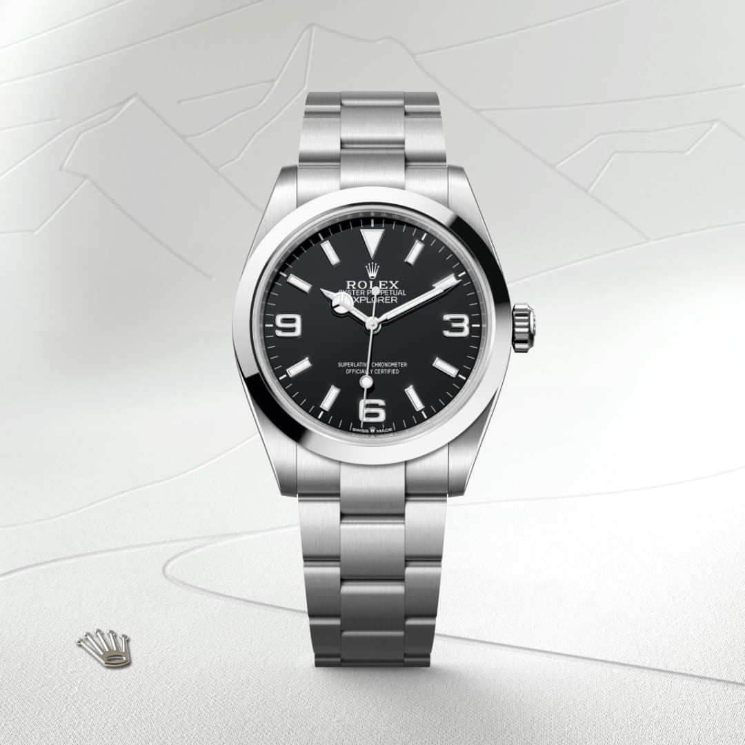 A silver Rolex Explorer watch with a black dial, silver hour markers, and a metal bracelet.