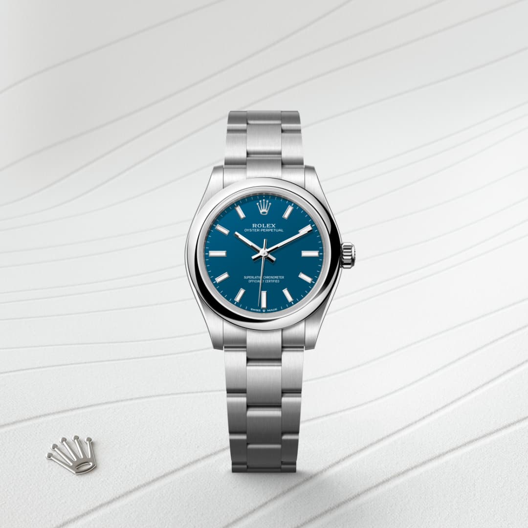 A silver Rolex watch with a blue face on a textured white background.
