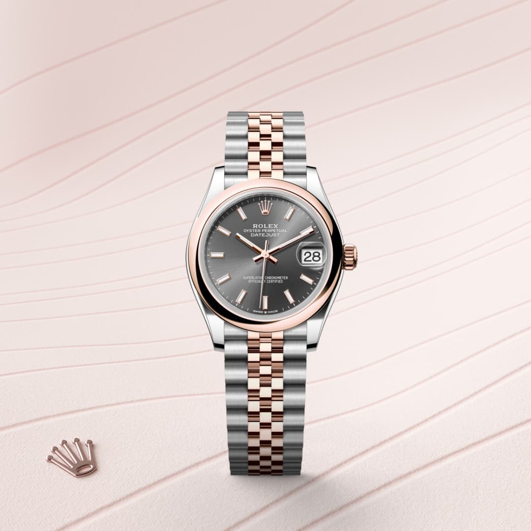 A Rolex watch with a two-tone metal band and black dial, displayed on a light textured background.