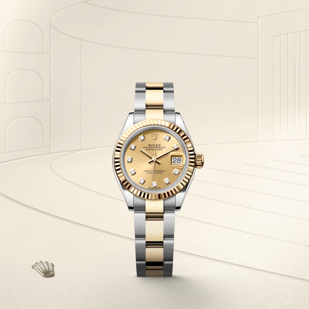 A two-tone Rolex watch with a gold dial, diamond hour markers, and a date display, set against a beige background.