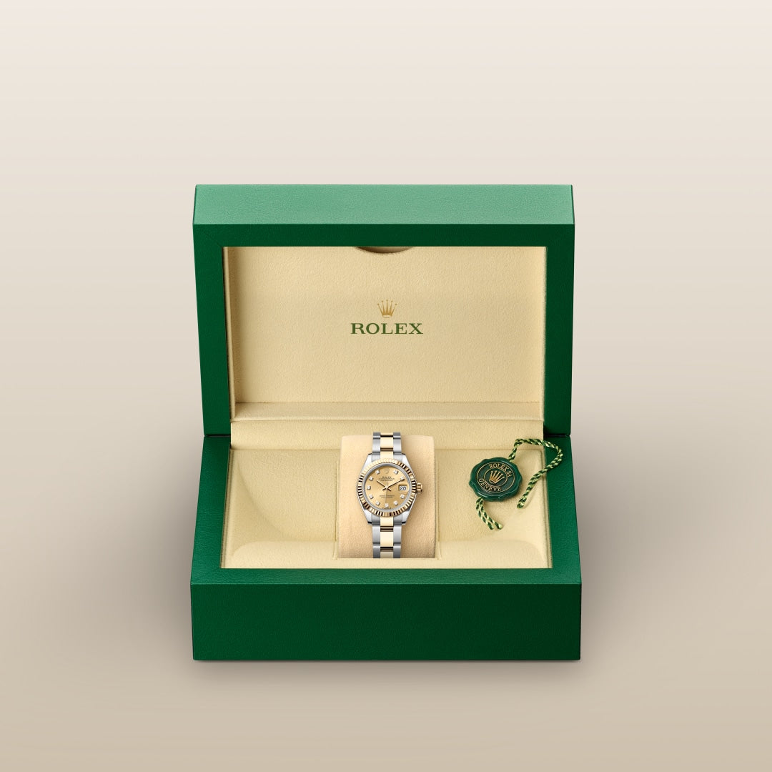 A Rolex watch in a green and cream display box with a green Rolex tag beside it.