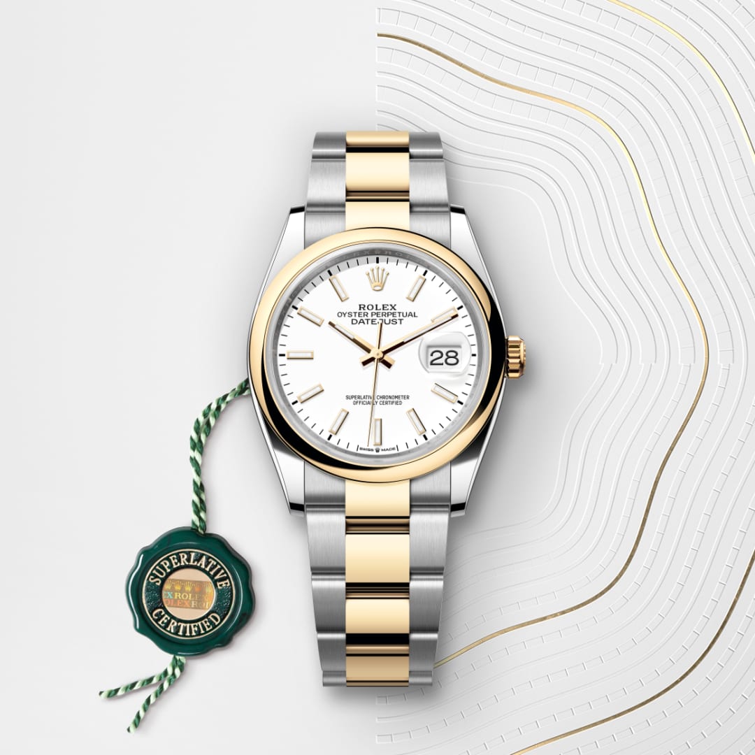 A two-tone Rolex Datejust watch with a white dial and gold accents, shown with a green Superlative Certified tag.