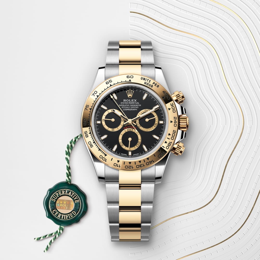 A Rolex Daytona watch with a gold and silver band, black dial, and a green Superlative Certified tag.