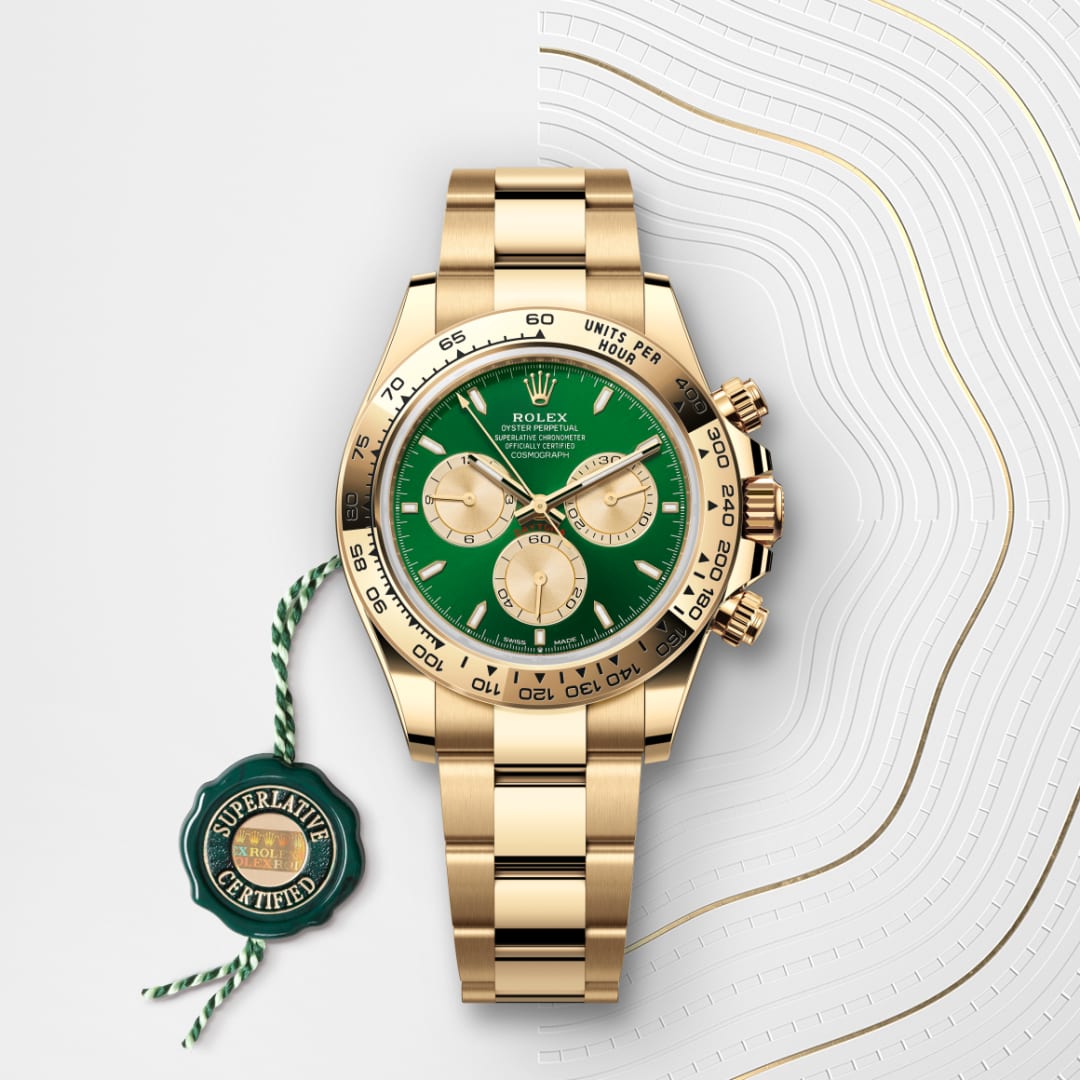 A gold Rolex watch with a green dial and three subdials, displayed with a Superlative Certified tag.