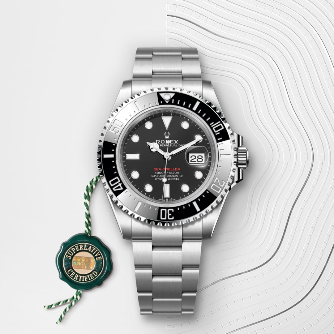 A silver Rolex Sea-Dweller watch with a black bezel and a green Superlative Certified tag.