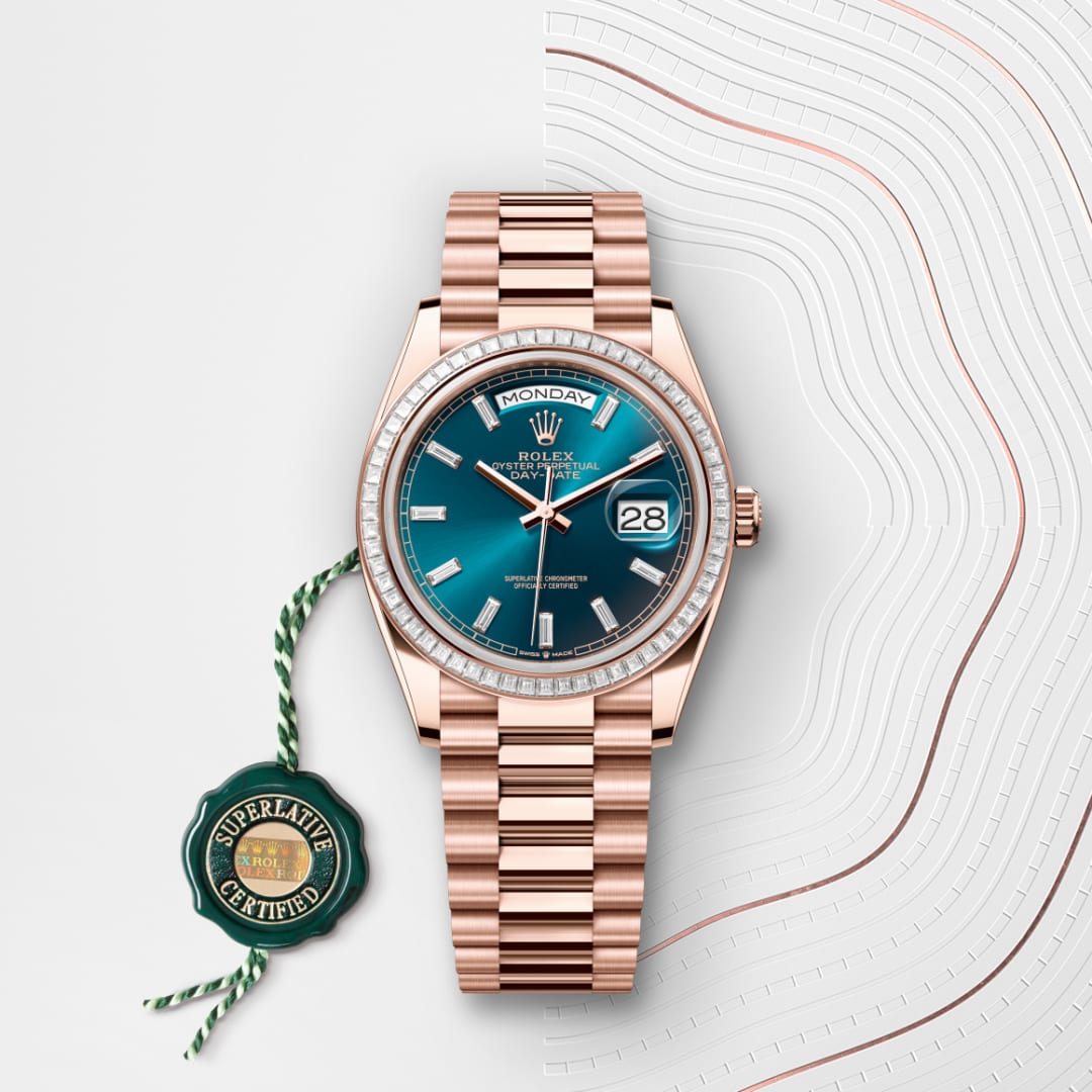 A rose gold Rolex watch with a blue face and diamond bezel next to a green Superlative Certified tag.