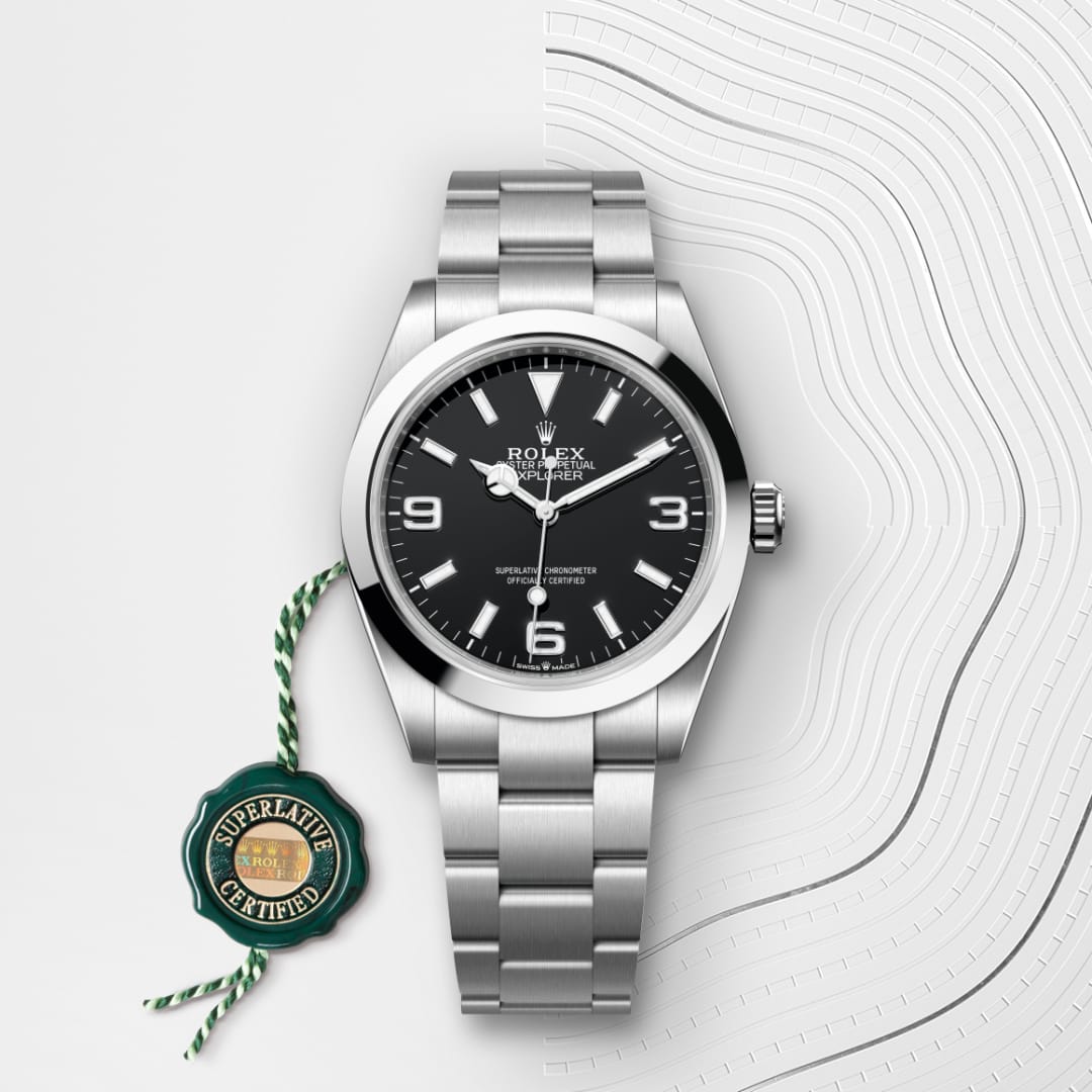 A silver Rolex wristwatch with a black face and metal band, next to a green Superlative Certified tag.