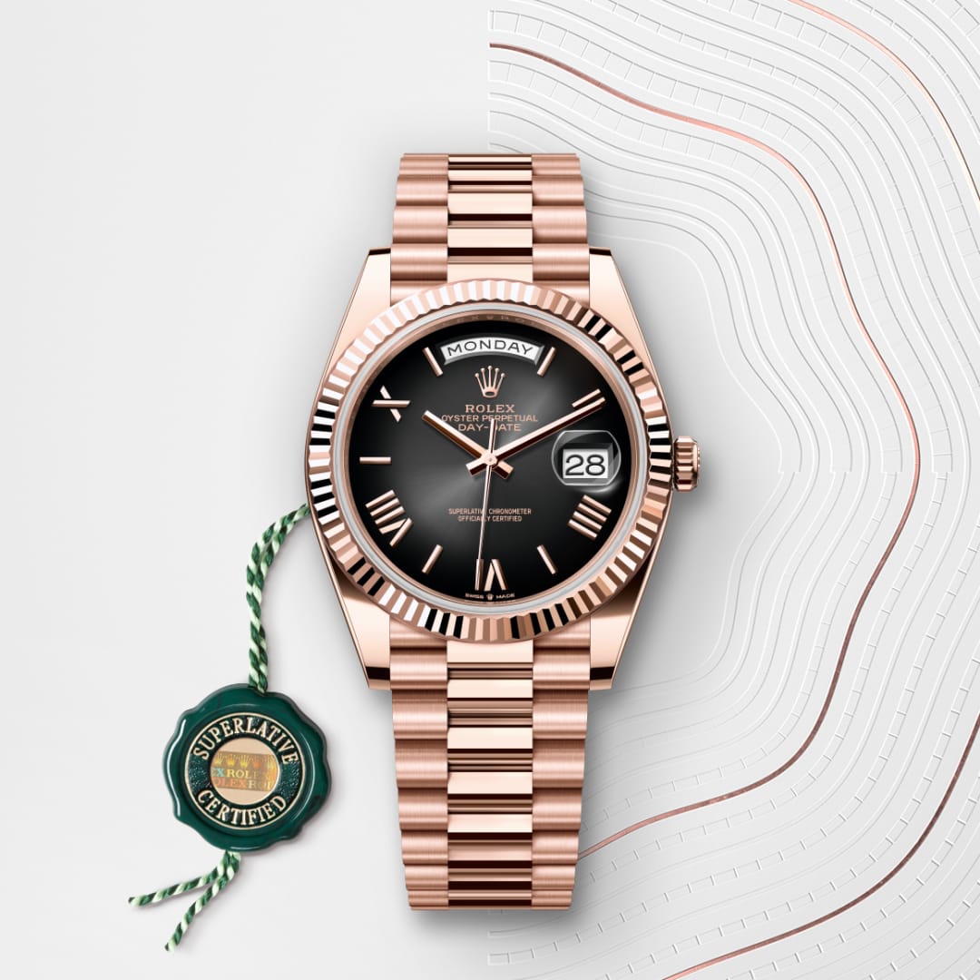 A rose gold Rolex watch with a black dial, date, and day display, beside a green Superlative Certified tag.