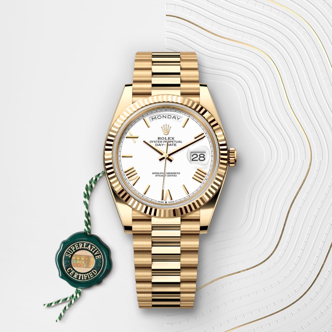 A gold Rolex watch with a white face displaying the day and date, next to a green Superlative Certified tag.