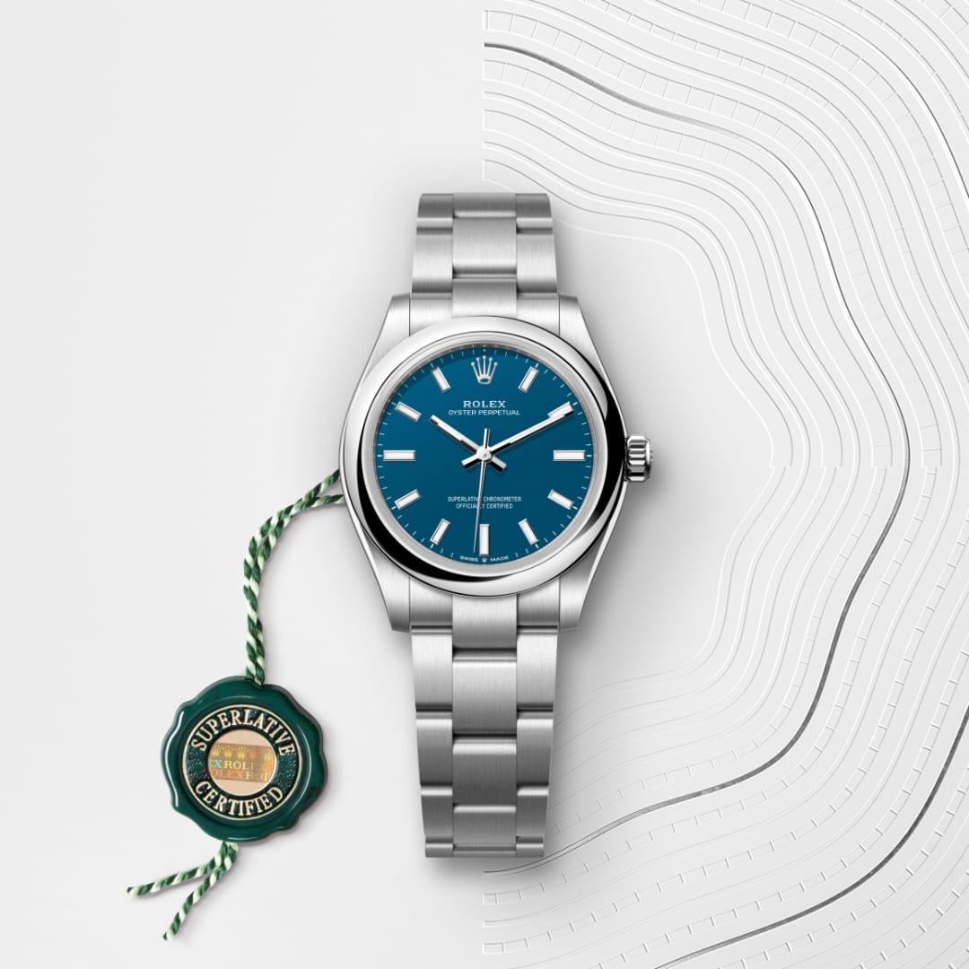 Silver Rolex watch with a blue dial and Superlative Certified tag on a white textured background.