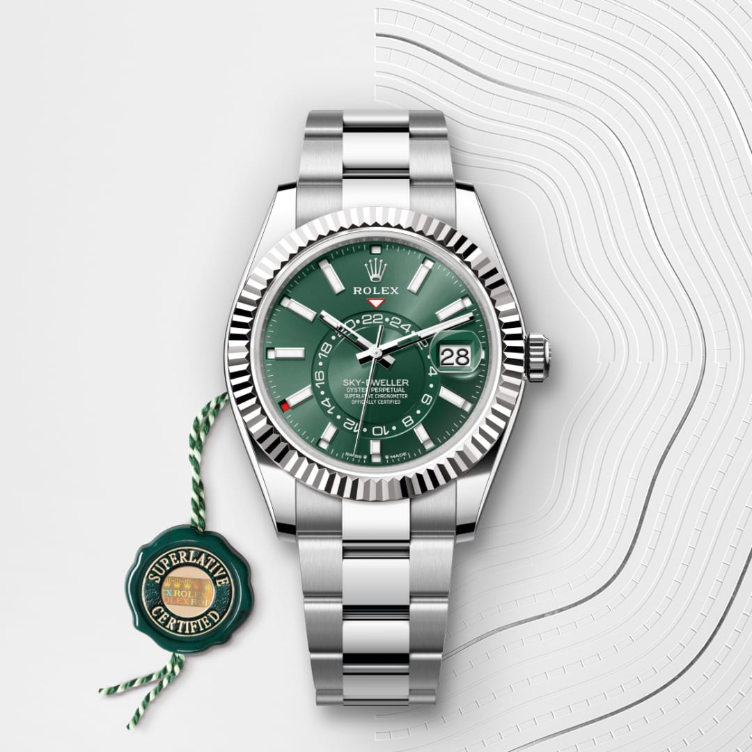 A silver Rolex Sky-Dweller watch with a green dial and date display, shown with a certification tag.