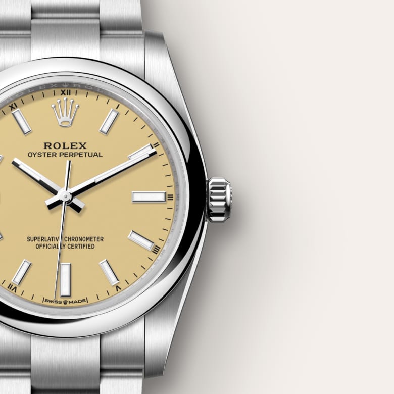 A Rolex Oyster Perpetual watch with a champagne-colored dial and a stainless steel bracelet.