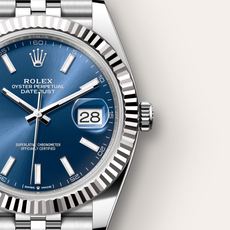 Close-up of a Rolex Datejust watch with a blue dial and silver hour markers, showing the date as 28.