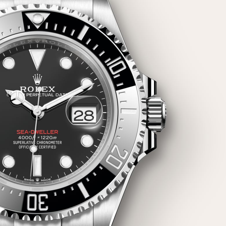 Close-up of a Rolex Sea-Dweller watch showing the date, black dial, and silver bezel.