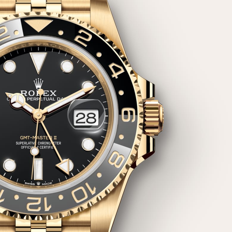 Close-up of a gold Rolex GMT-Master II watch showing the black dial, date window, and gold bezel.