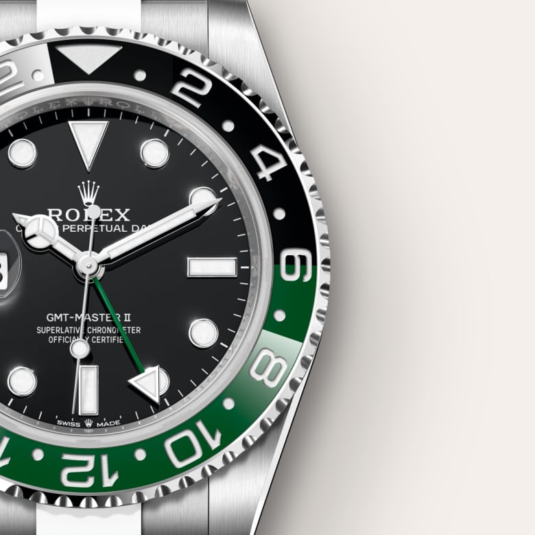 Close-up of a Rolex GMT-Master II watch with a black and green bezel, silver case, and black dial.