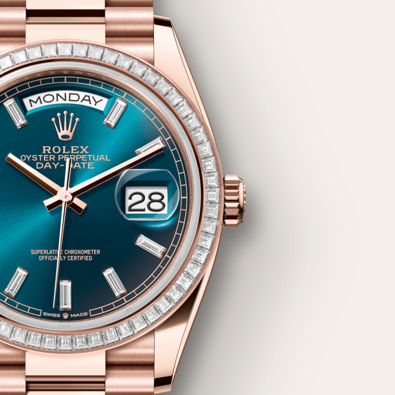 Rose gold Rolex Day-Date watch with blue dial, diamond bezel, and date window displaying 28 and Monday.