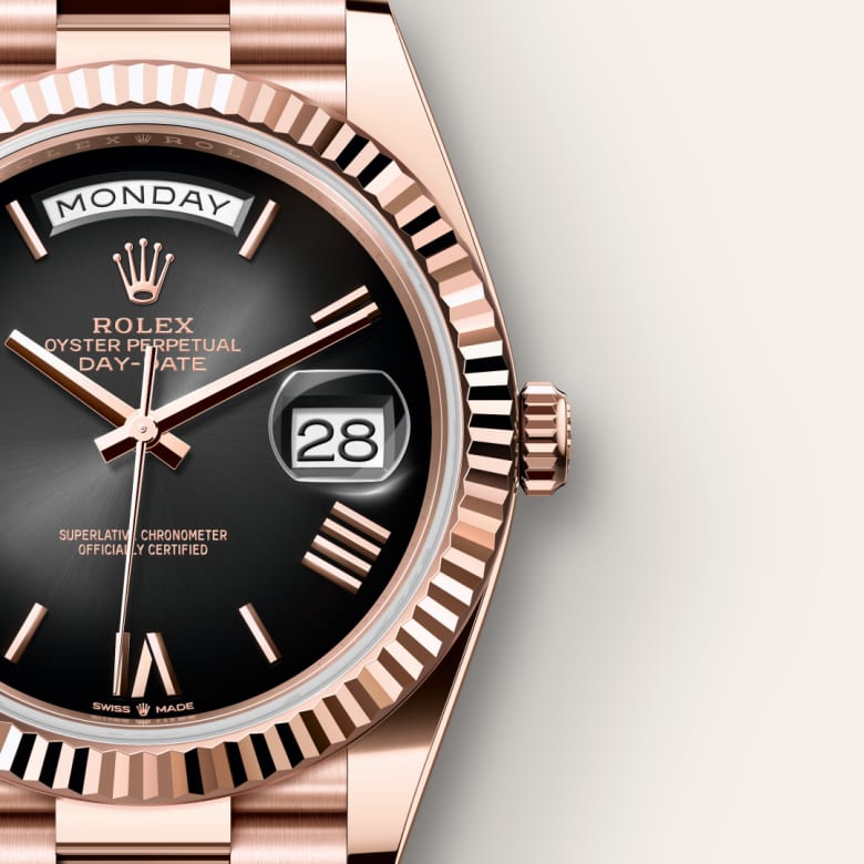 Close-up of a Rolex Day-Date watch with a black dial, date at 3 oclock, and day display at 12 oclock.