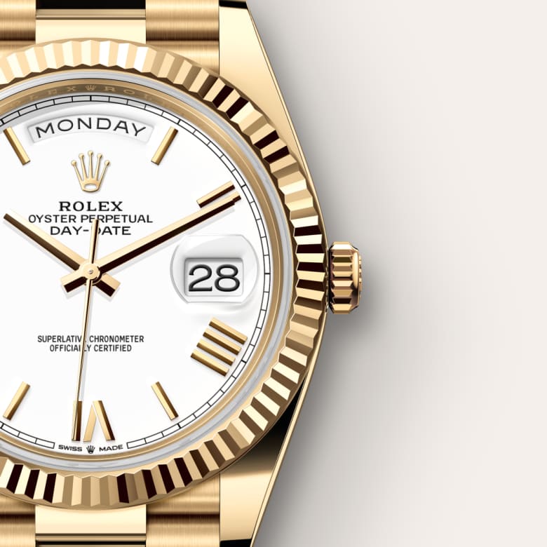 Close-up of a gold Rolex Oyster Perpetual Day-Date watch displaying Monday and the date as 28 on a white dial.