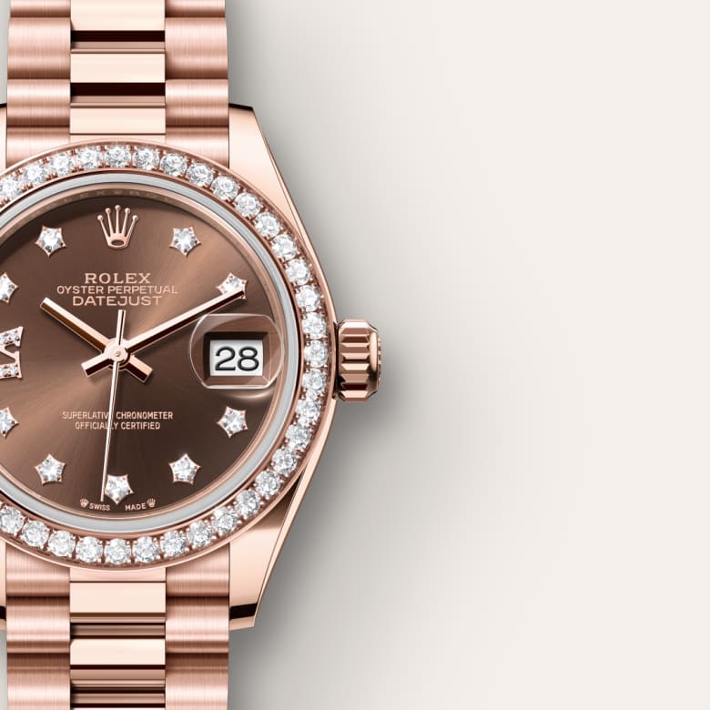 Close-up of a rose gold Rolex Datejust watch with diamond hour markers and a date display.