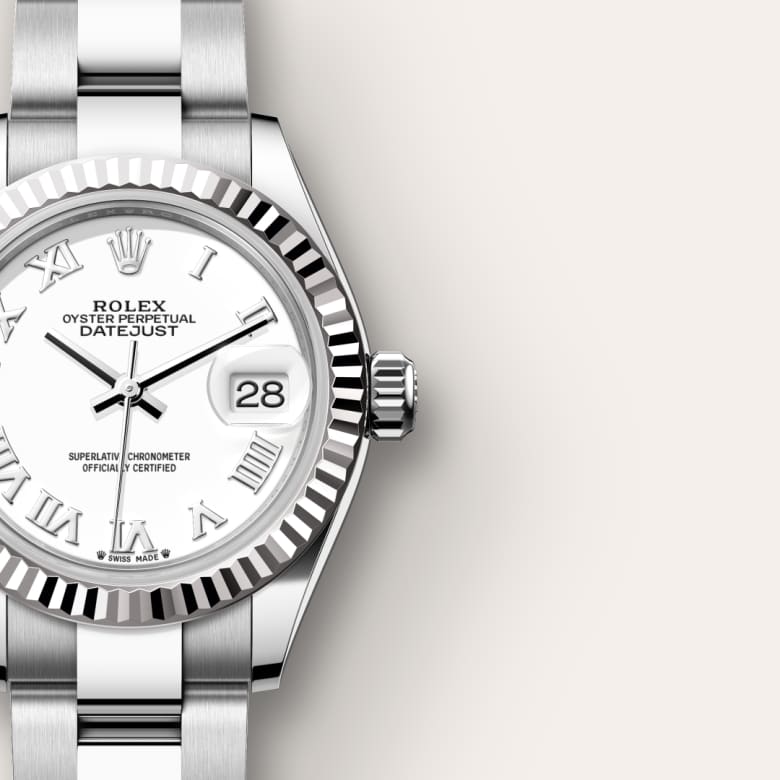 Close-up of a silver Rolex Datejust watch with a white dial and Roman numerals, showing the date at 3 o’clock.