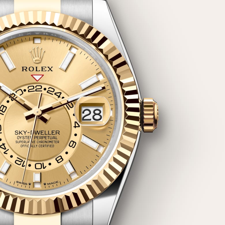 Close-up of a gold and silver Rolex Sky-Dweller watch showing the dial, date, and crown details.