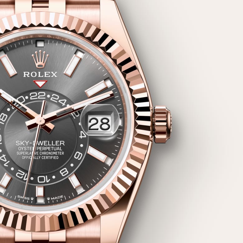 Close-up of a Rolex Sky-Dweller watch with a grey dial, date display, and rose gold bezel and bracelet.
