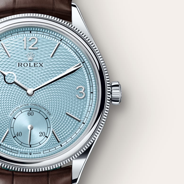 Close-up of a light blue Rolex watch face with silver detailing and a brown leather strap.