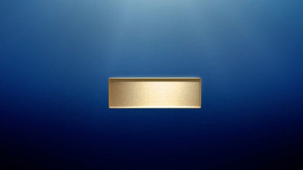 A gold rectangular bar centered on a gradient blue background.