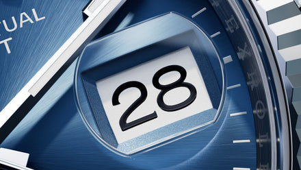 Close-up of a blue watch face displaying the date 28 in a prominent date window.