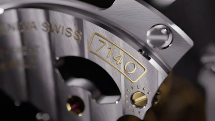 Close-up of a luxury Swiss watch movement with the number 7140 engraved in gold on a metal surface.