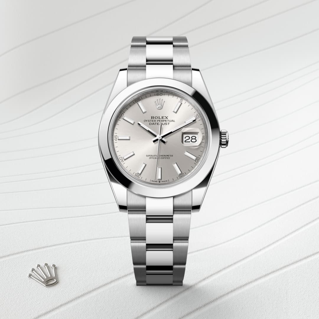 A silver Rolex Datejust watch with a white dial and metal bracelet, displayed on a textured white surface.