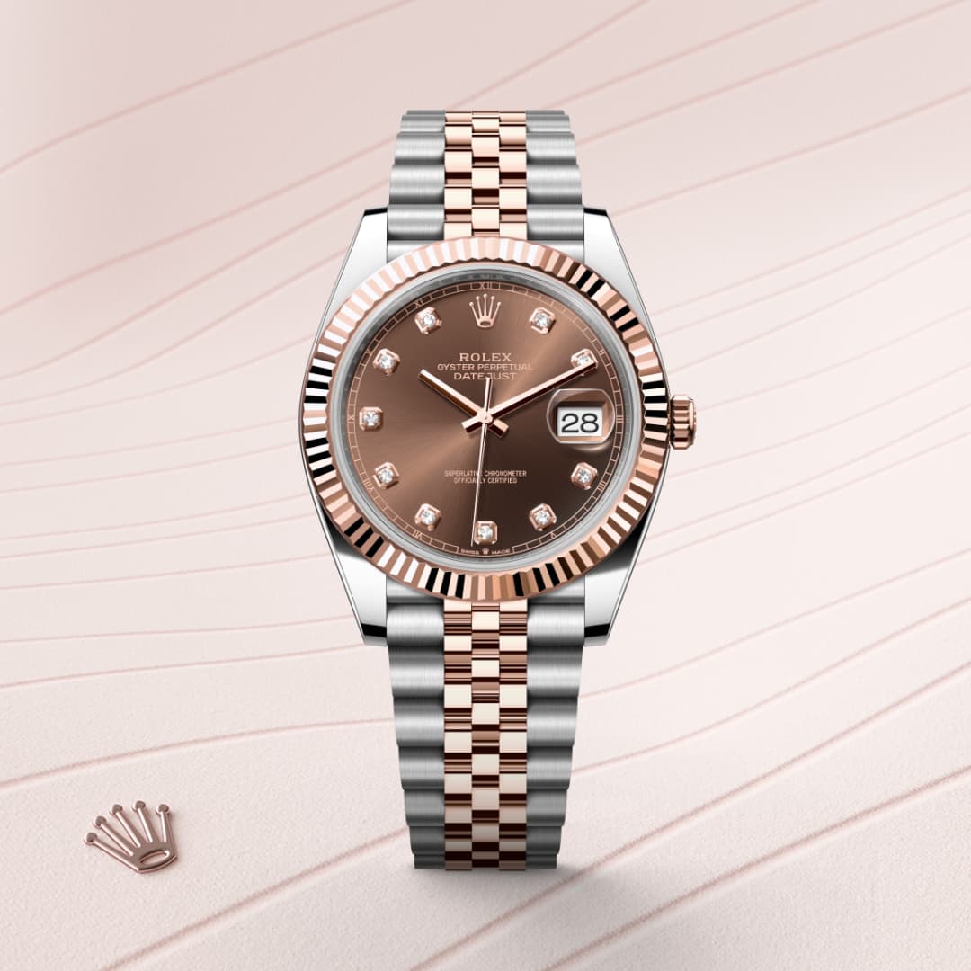A two-tone Rolex watch with a brown dial and diamond hour markers on a striped background.