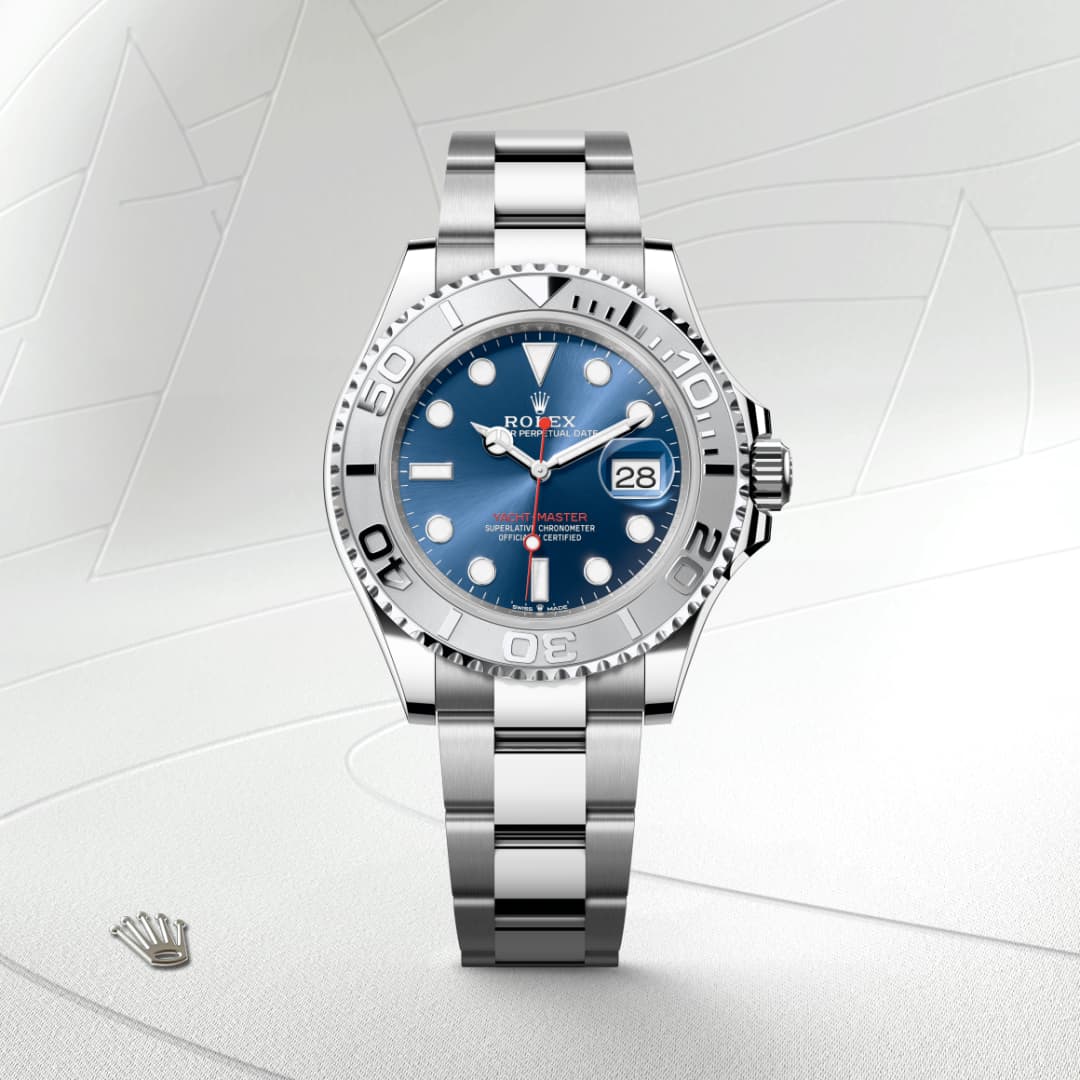 A silver Rolex Yacht-Master watch with a blue dial shown on a light, textured background.